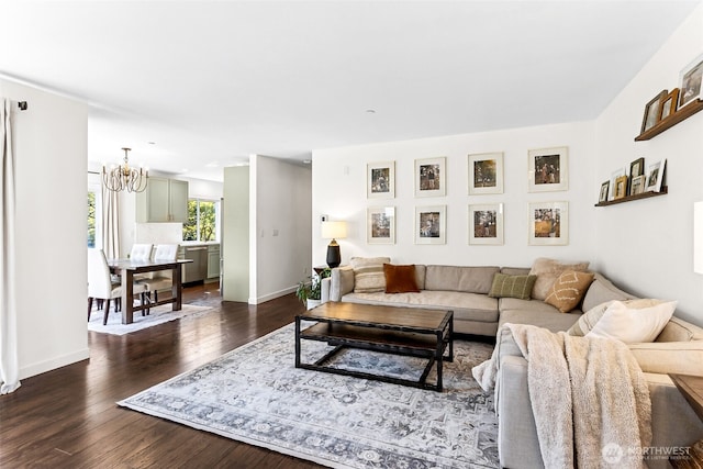 living room with baseboards, dark wood-style floors, and a notable chandelier