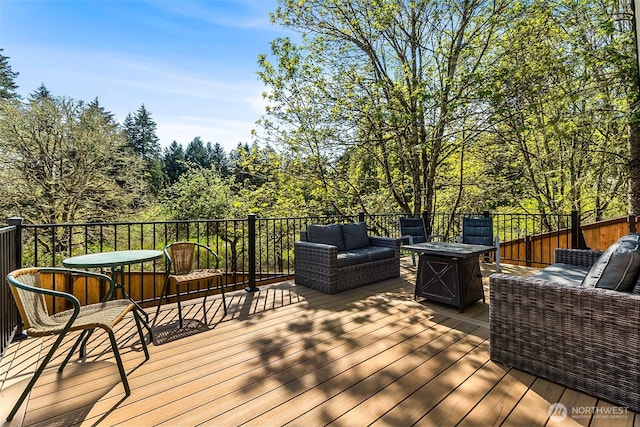 wooden deck featuring an outdoor living space with a fire pit
