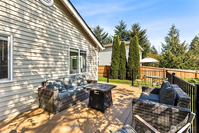 deck featuring an outdoor living space with a fire pit and fence