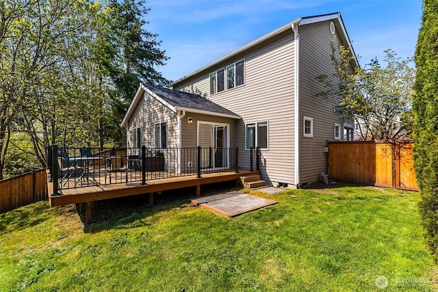 rear view of house featuring a yard, a deck, and fence