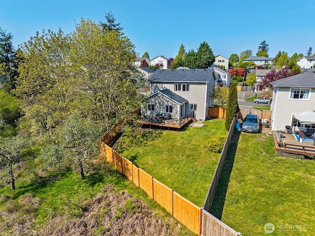 view of yard with a fenced backyard, a wooden deck, and a residential view