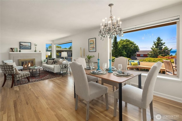 6743 40th Ave SW, Seattle, WA 98136 - dining space with healthy amount of natural light, wood finished floors, a chandelier, and a fireplace