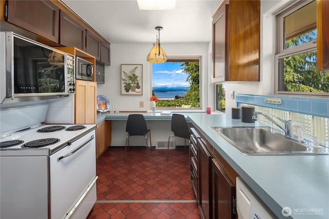 6743 40th Ave SW, Seattle, WA 98136 - kitchen featuring electric range, tasteful backsplash, pendant lighting, built in study area, and light countertops