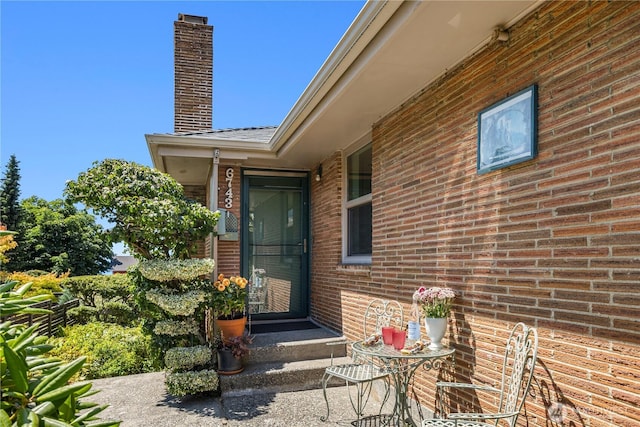 6743 40th Ave SW, Seattle, WA 98136 - doorway to property with brick siding and a chimney