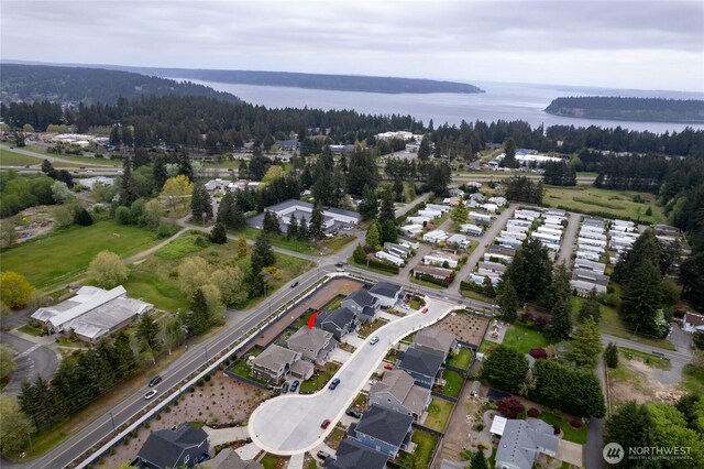 bird's eye view with a water view, a view of trees, and a residential view