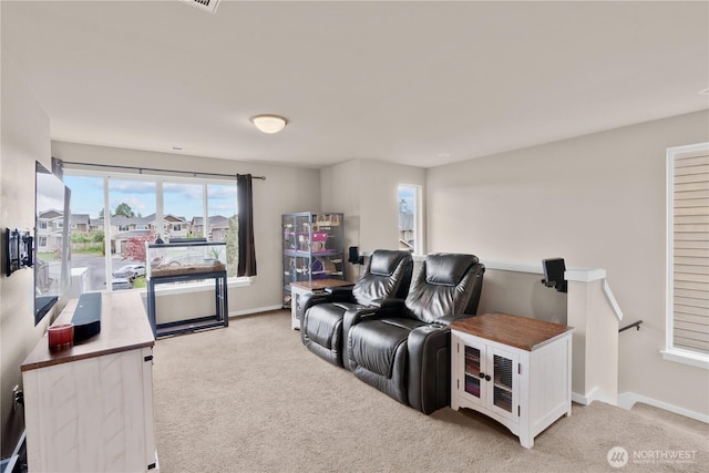 living room featuring plenty of natural light, baseboards, and light carpet