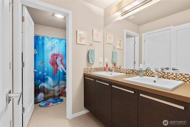bathroom featuring a sink, a shower with curtain, and double vanity