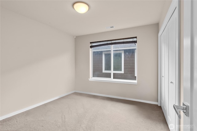 unfurnished bedroom featuring baseboards, carpet, visible vents, and a closet