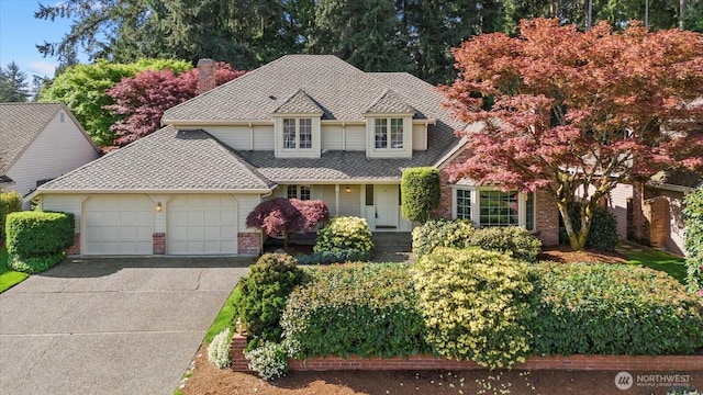traditional home featuring an attached garage, driveway, brick siding, roof with shingles, and a chimney