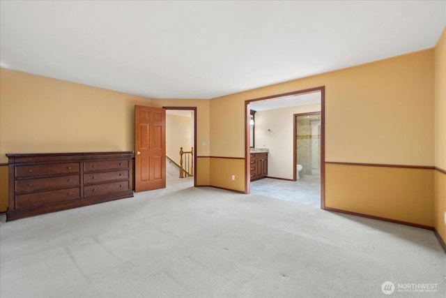 unfurnished room featuring light carpet and baseboards