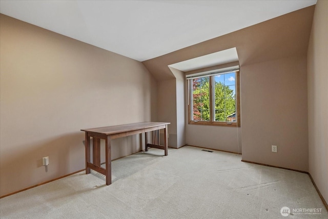 additional living space with light carpet and baseboards