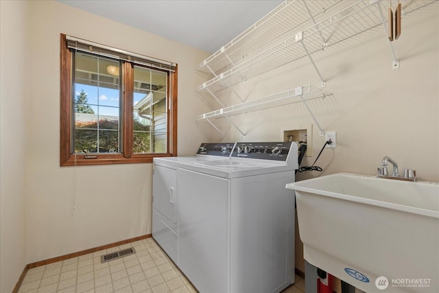 laundry room featuring washer and dryer, baseboards, and light flooring