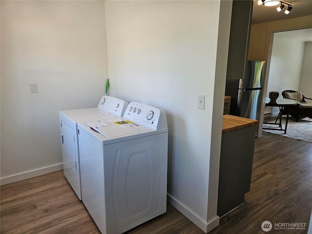 washroom featuring separate washer and dryer, baseboards, laundry area, and dark wood-style floors