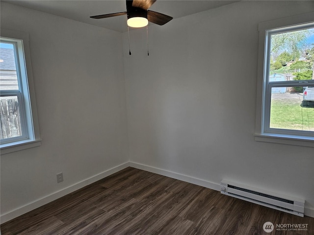 empty room with baseboards, a ceiling fan, a baseboard heating unit, and dark wood-style floors