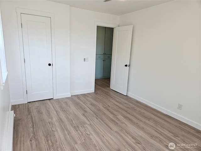 unfurnished bedroom featuring baseboards and light wood-style floors