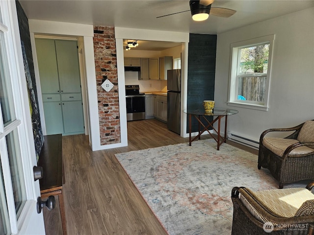 interior space featuring baseboards, a baseboard radiator, ceiling fan, and wood finished floors
