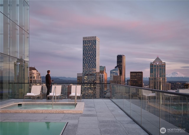 view of pool featuring a view of city and a hot tub