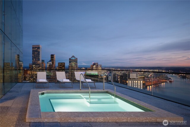 pool at dusk featuring a city view