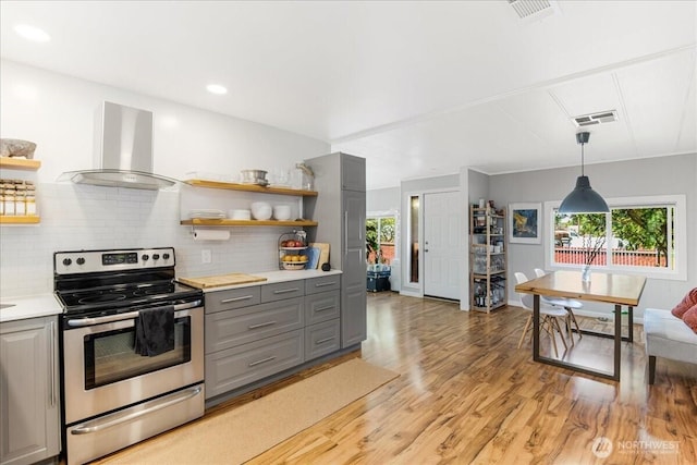 kitchen featuring wall chimney range hood, open shelves, gray cabinetry, and stainless steel electric stove