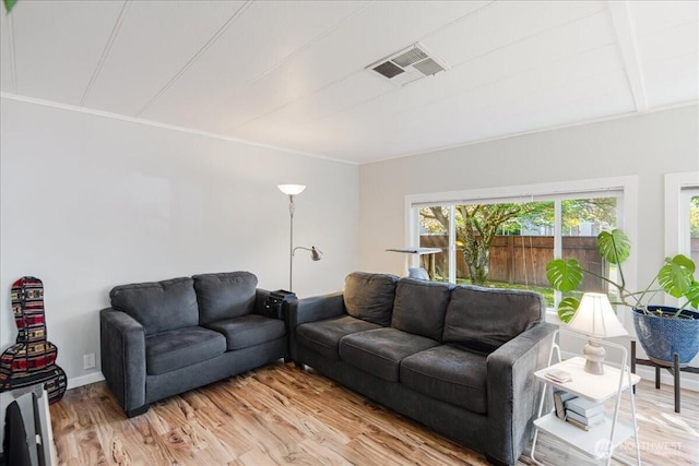 living room with visible vents, light wood-style floors, and crown molding