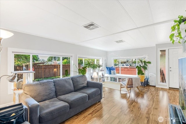 living area with visible vents and wood finished floors