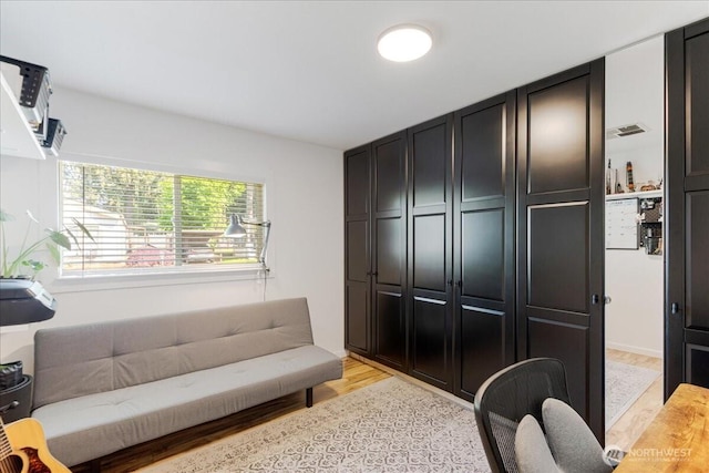 living area featuring light wood-type flooring and visible vents
