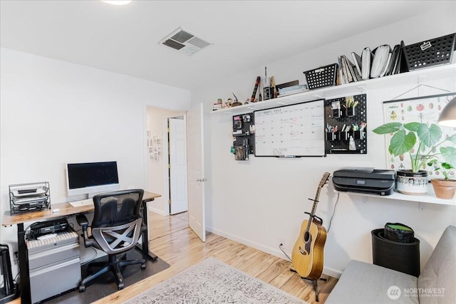 office area with visible vents, baseboards, and wood finished floors
