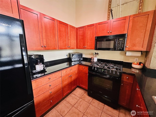 kitchen with light tile patterned flooring, dark countertops, black appliances, and a toaster