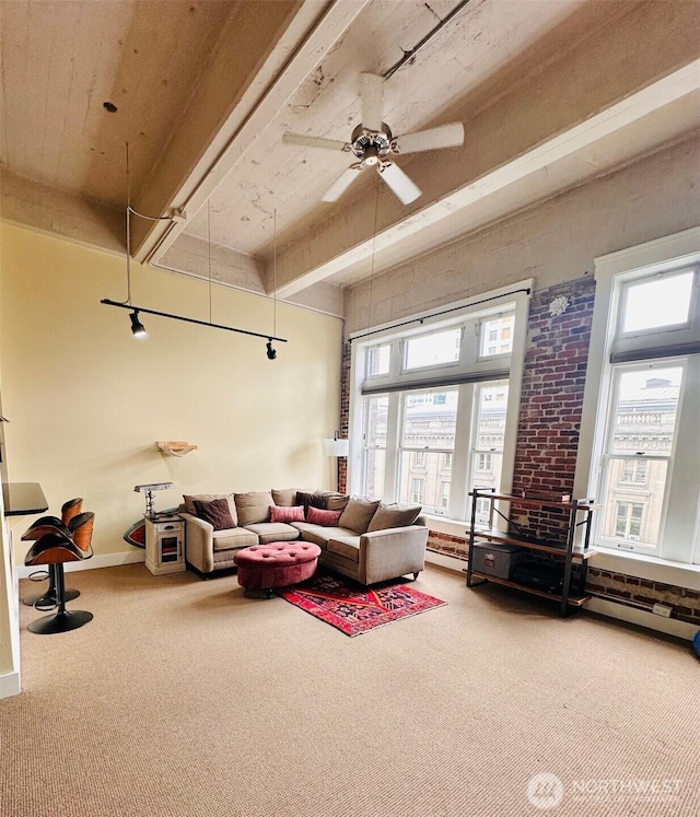 living room with carpet floors, baseboards, ceiling fan, and a healthy amount of sunlight