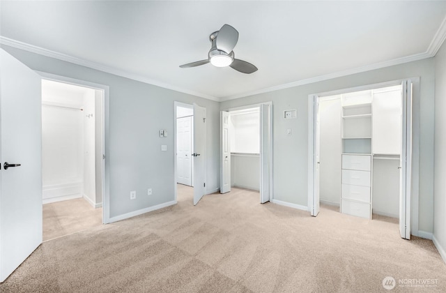 unfurnished bedroom featuring light colored carpet, multiple closets, and crown molding