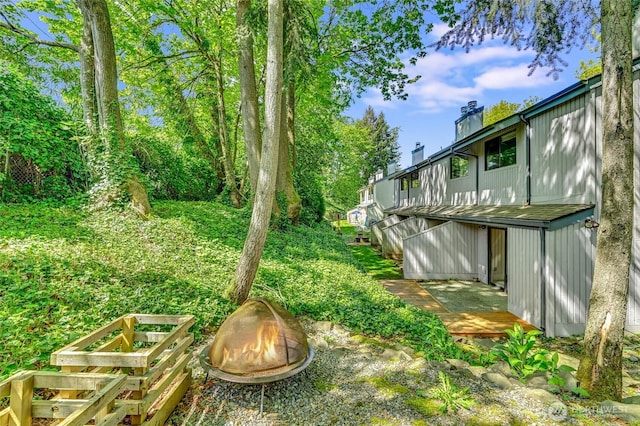 view of yard featuring an outdoor fire pit and a deck