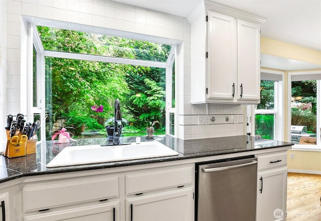 kitchen featuring decorative backsplash, light wood-style floors, white cabinetry, a sink, and dishwasher
