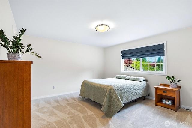bedroom with baseboards, light colored carpet, and visible vents