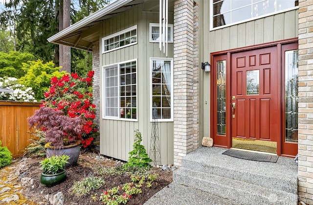 entrance to property featuring brick siding and fence