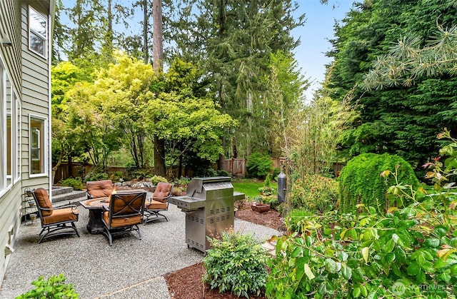 view of patio featuring a fenced backyard, a fire pit, and grilling area