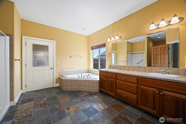 full bath featuring a sink, a stall shower, a bath, and stone tile flooring