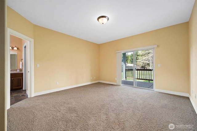 spare room with baseboards and carpet