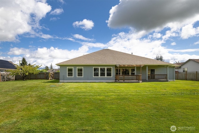 rear view of property with a lawn, a pergola, and a fenced backyard