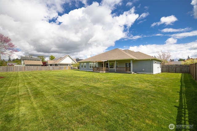 back of property featuring a fenced backyard and a yard