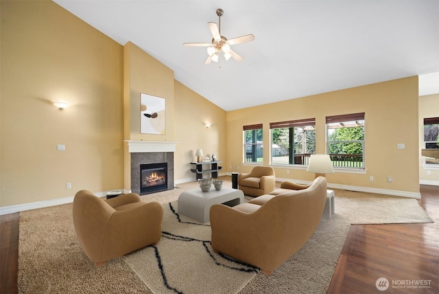 living room featuring ceiling fan, a high end fireplace, baseboards, high vaulted ceiling, and carpet flooring
