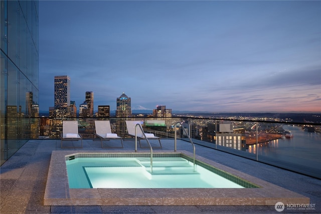 pool at dusk featuring a city view
