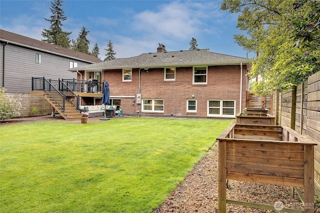 rear view of house with a chimney, stairway, brick siding, an outdoor hangout area, and a fenced backyard