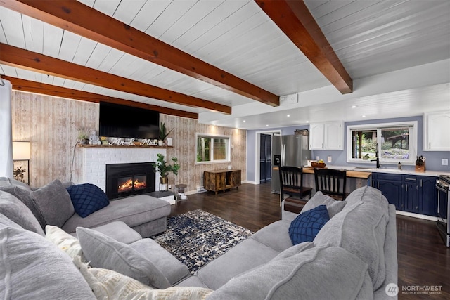 4130 Lakeway Dr, Bellingham, WA 98229 - living room with a fireplace, wood walls, baseboards, beamed ceiling, and dark wood-style floors