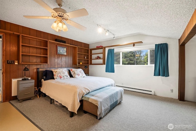 4130 Lakeway Dr, Bellingham, WA 98229 - carpeted bedroom with wooden walls, a ceiling fan, a textured ceiling, and a baseboard heating unit