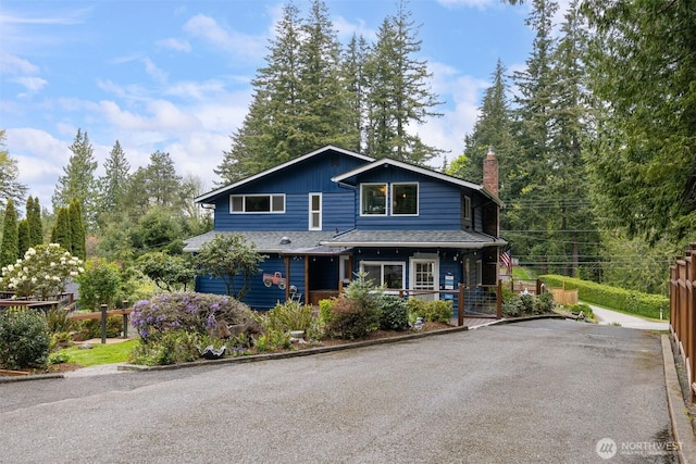 4130 Lakeway Dr, Bellingham, WA 98229 - view of front of home with a shingled roof, aphalt driveway, covered porch, and a chimney