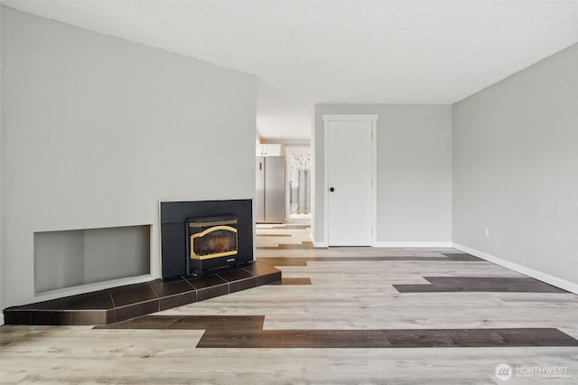 unfurnished living room with baseboards and wood finished floors