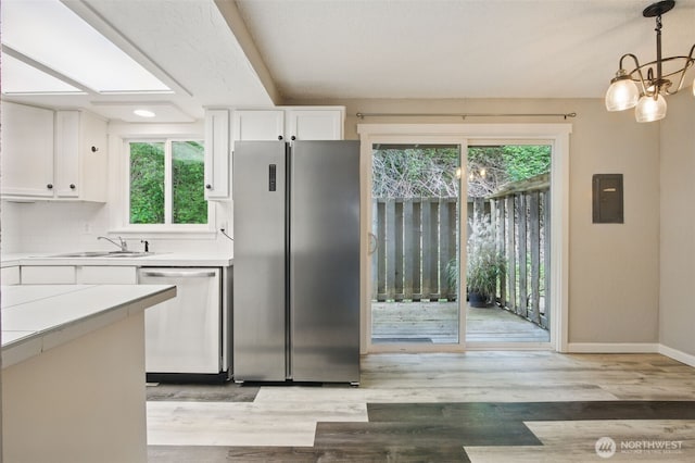 kitchen with stainless steel appliances, plenty of natural light, and white cabinetry