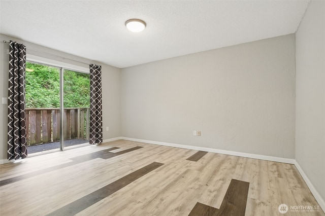 empty room with baseboards and wood finished floors