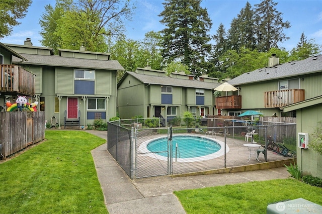 pool featuring a lawn, entry steps, fence, and a patio
