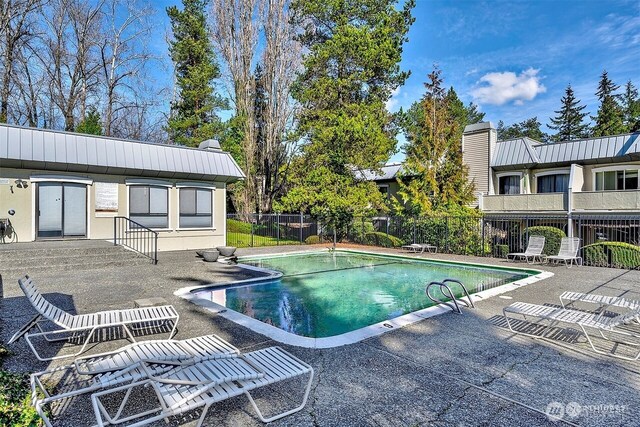community pool featuring a patio and fence